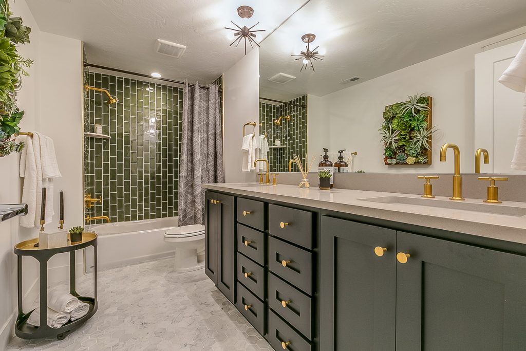 About Us - Green is the theme in this beautiful bathroom with brass faucets and fixtures